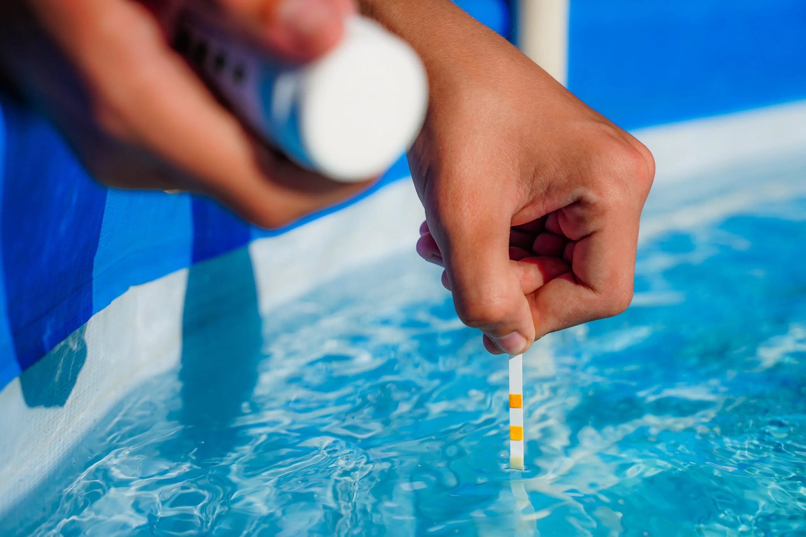 checking-aScreened Pools Full Servicewater-quality-pool-with-help-test-strip-with-ph-value-chlorine-algaecide-min Screened Pools Full Service